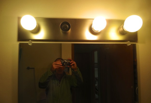 Three generations of light bulbs: Left, a 7.5-watt LED (cool to the touch), Middle, 100-watt incandescent (scalding), Right, 11-watt CFL (warm)