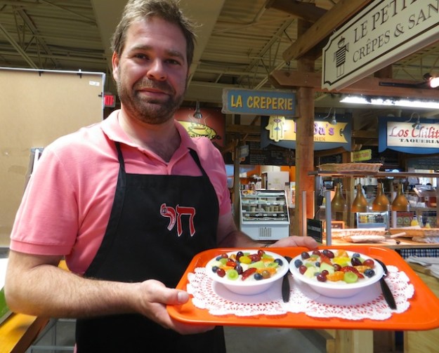 Danny Korduner delivers two fruit-covered bowls of made-to-order oatmeal at Margarita's Dishes in the Calgary Farmers' Market
