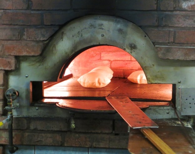 The pita gets puffy, slightly crispy and hot in the oven
