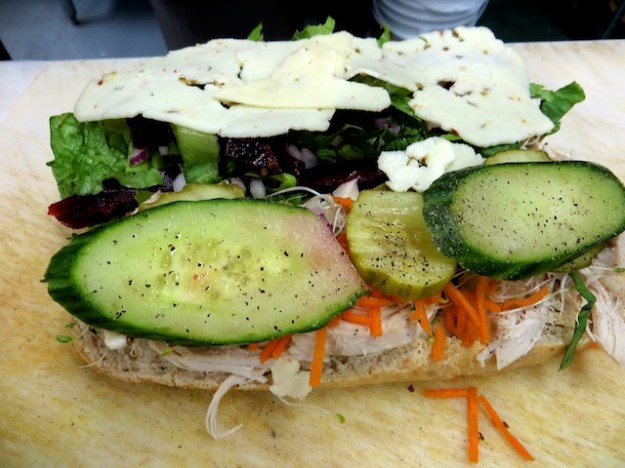 Chicken sandwich with a lot of fixings on a house-baked whole wheat roll
