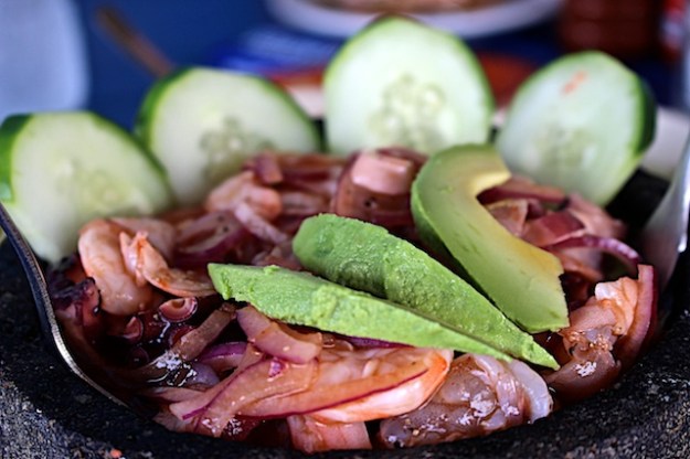 A mocajete bowl laden with marinated shrimp and octopus