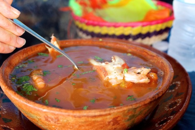 A big bowl of soup swimming with seafood